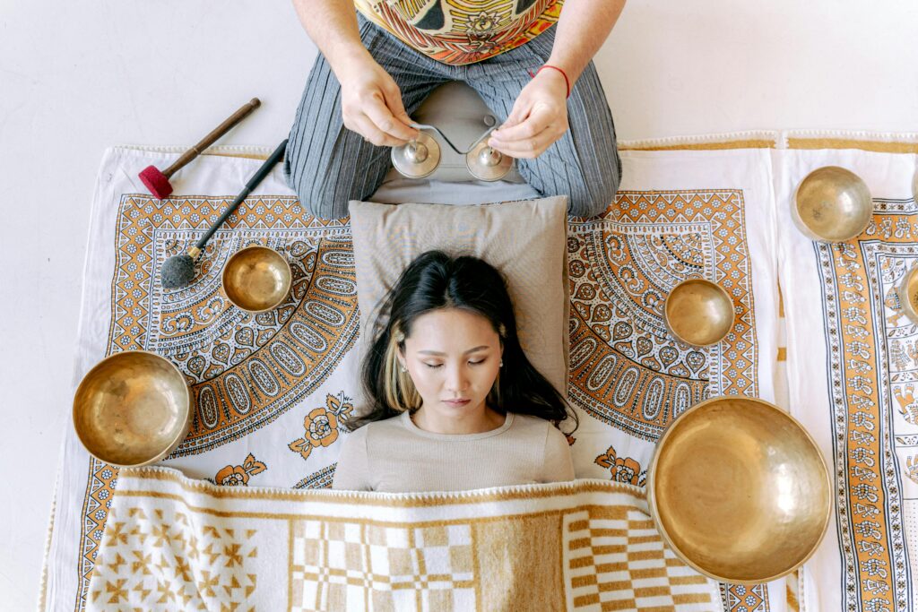 A woman enjoying a relaxation session with Tibetan singing bowls for wellness.
